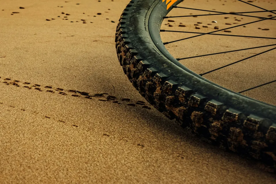 Brede fietsband van een mountainbike in het zand op het strand