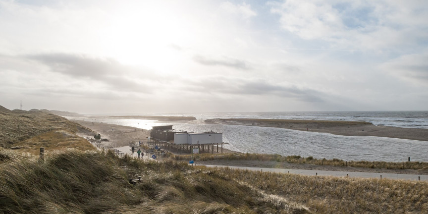 The lagoon on the beach with a beach pavilion in the low sun